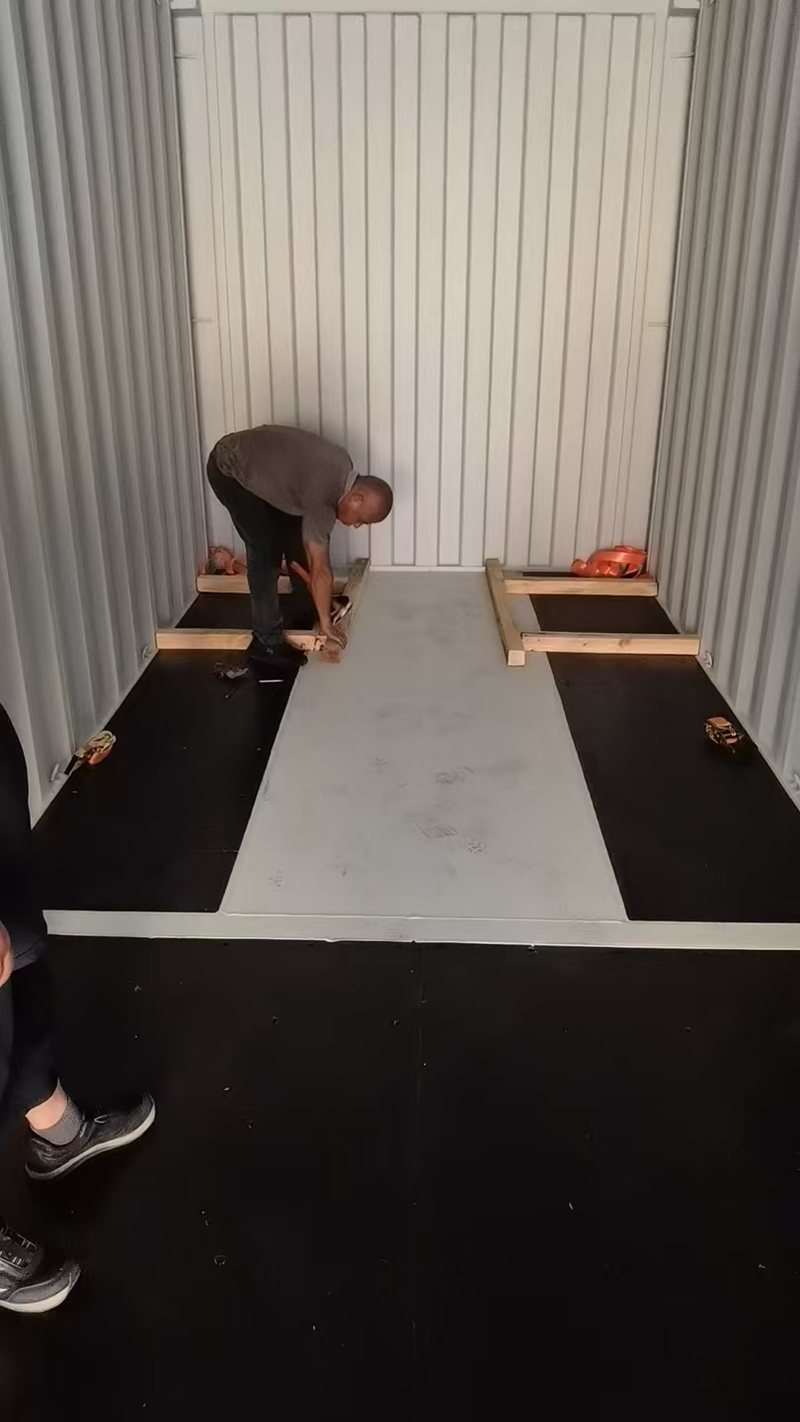 沙特电缆项目实拍:工作人员在集装箱内布置木条,柜底两侧可见木质框架
